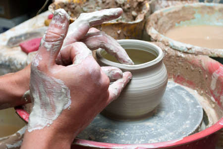 hands of a potter, creating an earthen jar on the circleの写真素材