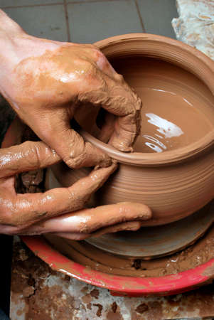 hands of a potter, creating an earthen jar on the circleの写真素材