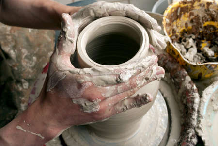 hands of a potter, creating an earthen jar on the circleの写真素材
