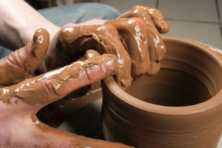 hands of a potter, creating an earthen jar on the circleの写真素材