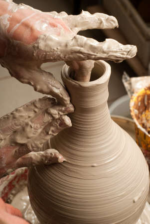 hands of a potter, creating an earthen jar on the circleの写真素材