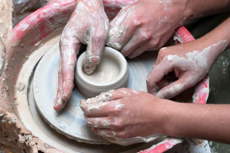 hands of a potter, creating an earthen jar on the circleの写真素材