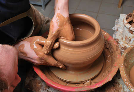hands of a potter, creating an earthen jar on the circleの写真素材