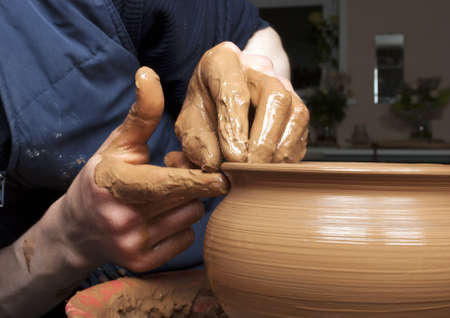 hands of a potter, creating an earthen jar on the circleの写真素材