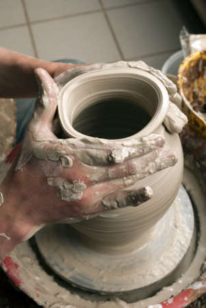 hands of a potter, creating an earthen jar on the circleの写真素材