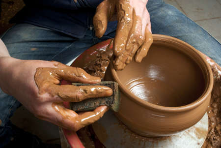 hands of a potter, creating an earthen jar on the circleの写真素材
