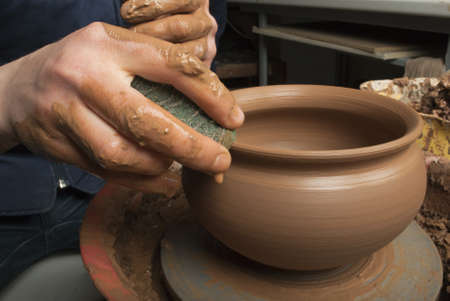 hands of a potter, creating an earthen jar on the circleの写真素材
