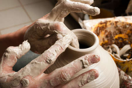 hands of a potter, creating an earthen jar on the circleの写真素材