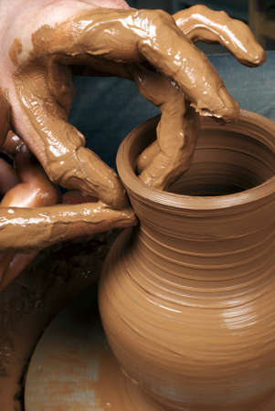 hands of a potter, creating an earthen jar on the circleの写真素材