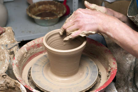 hands of a potter, creating an earthen jar on the circleの写真素材
