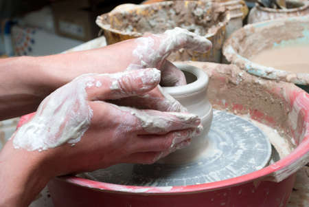 hands of a potter, creating an earthen jar on the circleの写真素材