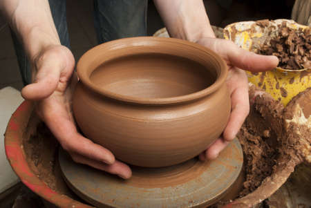 hands of a potter, creating an earthen jar on the circleの写真素材