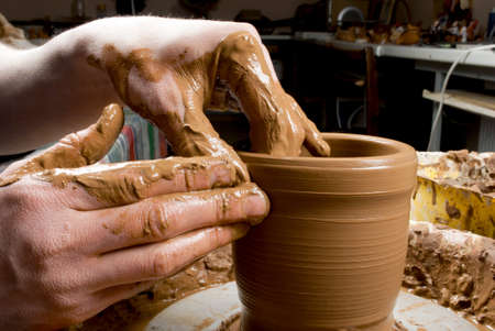 hands of a potter, creating an earthen jar on the circleの写真素材
