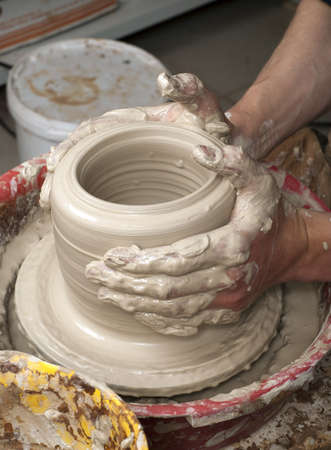 hands of a potter, creating an earthen jar on the circleの写真素材