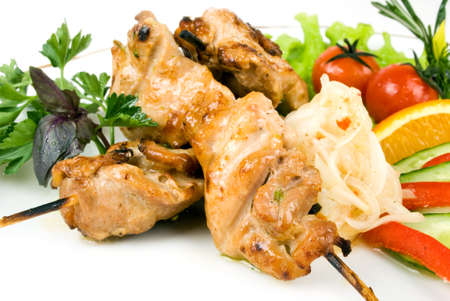 pork (or chicken) on a grill spit with saladの写真素材