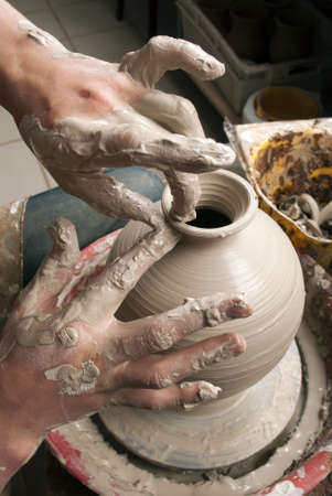 hands of a potter, creating an earthen jar on the circleの写真素材