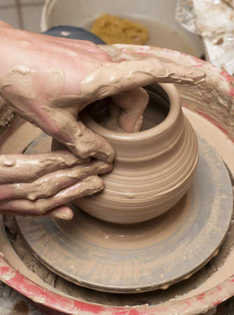 hands of a potter, creating an earthen jar on the circleの写真素材
