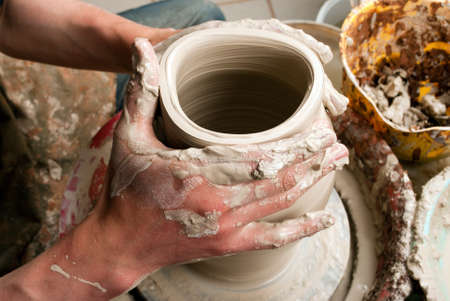 hands of a potter, creating an earthen jar on the circleの写真素材