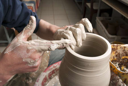 hands of a potter, creating an earthen jar on the circleの写真素材