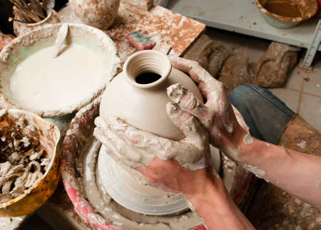 hands of a potter, creating an earthen jar on the circleの写真素材