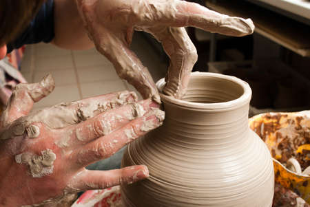 hands of a potter, creating an earthen jar on the circleの写真素材