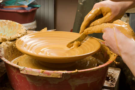 hands of a potter, creating an earthen jar on the circleの写真素材