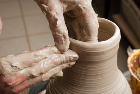 hands of a potter, creating an earthen jar on the circleの写真素材