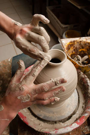 hands of a potter, creating an earthen jar on the circleの写真素材