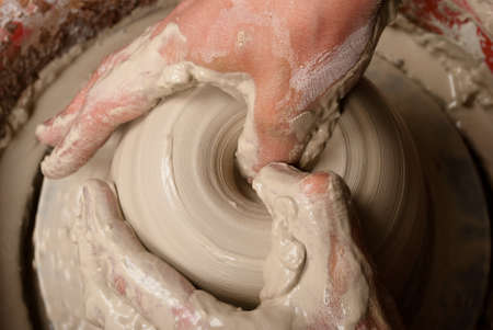 hands of a potter, creating an earthen jar on the circleの写真素材