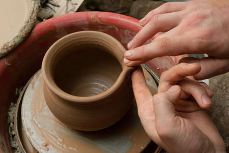 hands of a potter, creating an earthen jar on the circleの写真素材