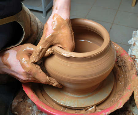 hands of a potter, creating an earthen jar on the circleの写真素材