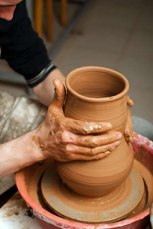 hands of a potter, creating an earthen jar on the circleの写真素材