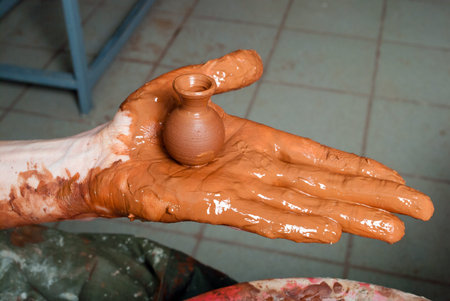 hands of a potter, creating an earthen jar on the circle