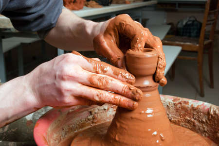 hands of a potter, creating an earthen jar on the circleの写真素材