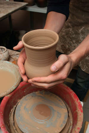hands of a potter, creating an earthen jar on the circleの写真素材