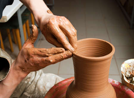hands of a potter, creating an earthen jar on the circleの写真素材