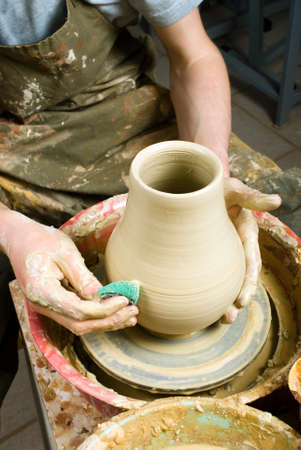 hands of a potter, creating an earthen jar on the circleの写真素材