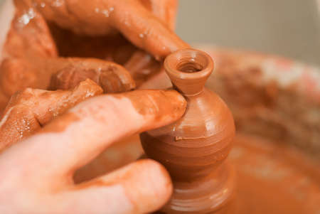 hands of a potter, creating an earthen jar on the circleの写真素材