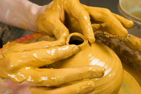 hands of a potter, creating an earthen jar on the circleの写真素材