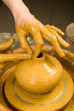 hands of a potter, creating an earthen jar of red clayの写真素材