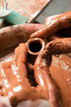 hands of a potter, creating an earthen jar on the circleの写真素材