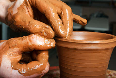 hands of a potter, creating an earthen jar on the circleの写真素材