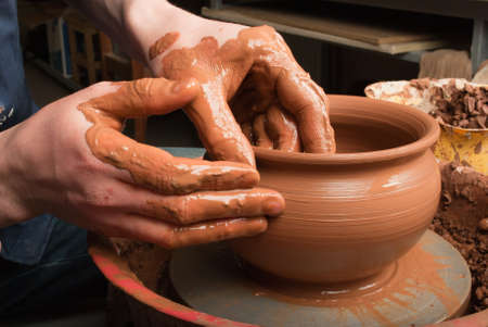 hands of a potter, creating an earthen jar on the circleの写真素材