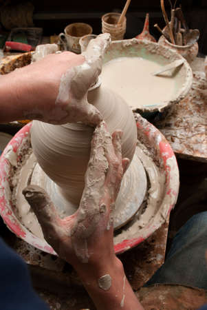 hands of a potter, creating an earthen jar on the circleの写真素材