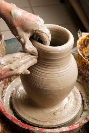 hands of a potter, creating an earthen jar on the circleの写真素材