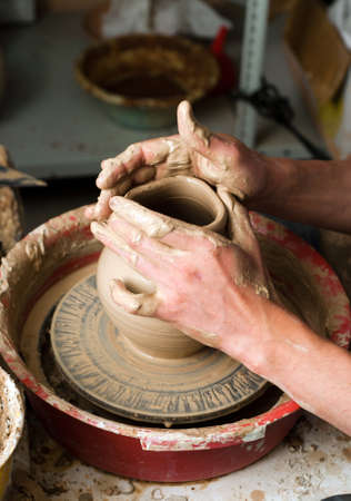 hands of a potter, creating an earthen jar on the circleの写真素材