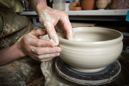 hands of a potter, creating an earthen jar on the circleの写真素材