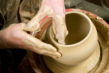 hands of a potter, creating an earthen jar of white clayの写真素材