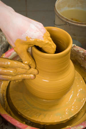hands of a potter, creating an earthen jar on the circleの写真素材