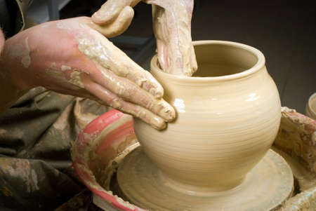 hands of a potter, creating an earthen jar on the circleの写真素材